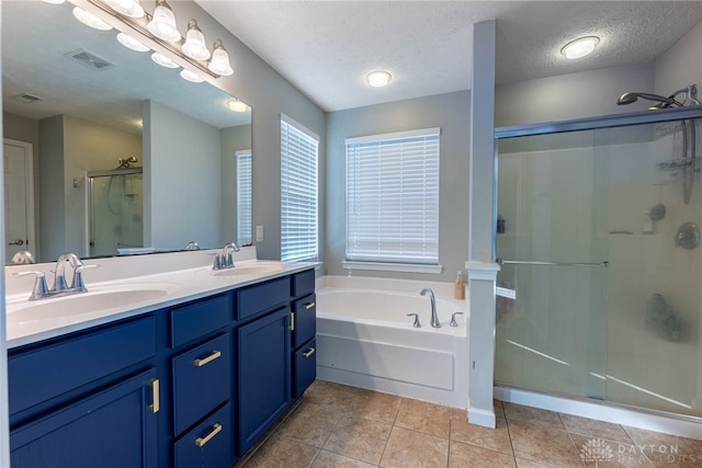 bathroom with a bath, a shower stall, a sink, and tile patterned floors