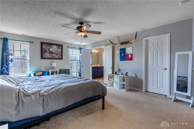 bedroom featuring a textured ceiling, a ceiling fan, baseboards, carpet, and ensuite bath