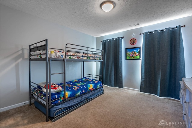 carpeted bedroom featuring baseboards, visible vents, and a textured ceiling