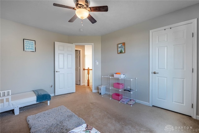 bedroom with a ceiling fan, light carpet, and baseboards