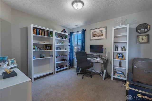 home office featuring a textured ceiling, carpet floors, and visible vents