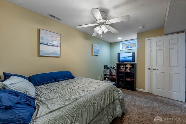 carpeted bedroom featuring ceiling fan, visible vents, and baseboards