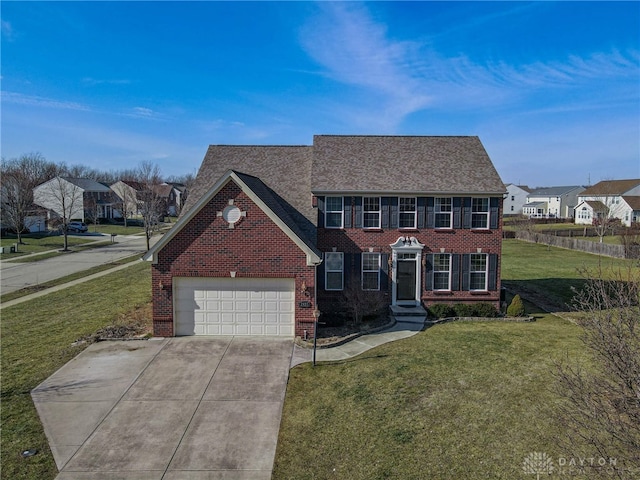 colonial inspired home with an attached garage, brick siding, a residential view, and a front yard