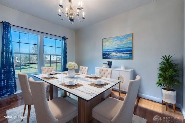 dining area with an inviting chandelier, baseboards, and wood finished floors