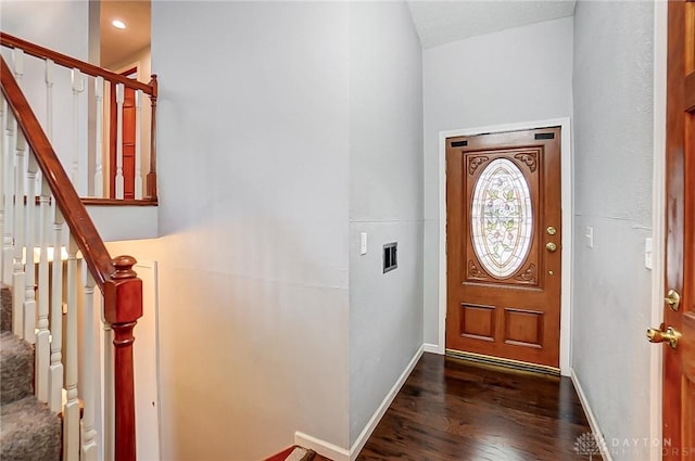 foyer featuring dark wood-type flooring, stairway, and baseboards