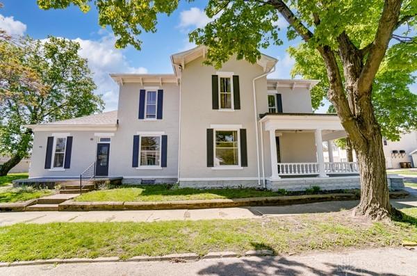 201 E Somers St, Eaton, OH 45320 - view of front of property with a porch, stucco siding, and a front yard