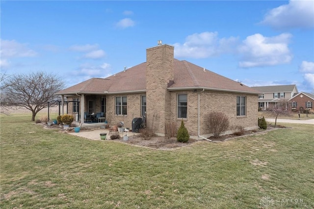 back of house with a lawn and a patio area