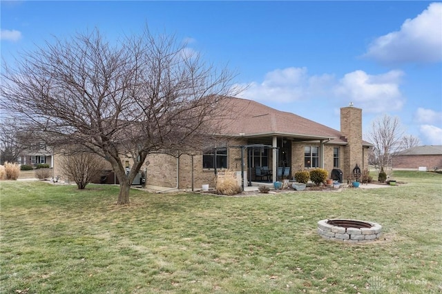 back of house with a yard and a fire pit