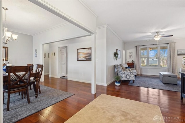 dining space with dark hardwood / wood-style flooring, crown molding, and ceiling fan with notable chandelier