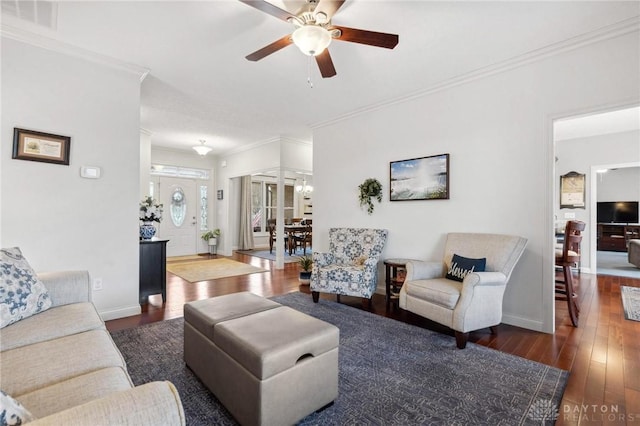 living room with dark hardwood / wood-style flooring, ceiling fan with notable chandelier, and ornamental molding