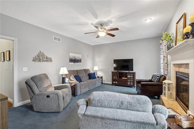 living room featuring ceiling fan, carpet flooring, and a tiled fireplace