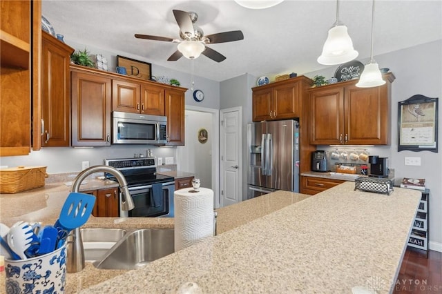 kitchen with appliances with stainless steel finishes, dark hardwood / wood-style floors, decorative light fixtures, sink, and ceiling fan