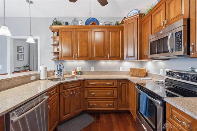 kitchen featuring dark hardwood / wood-style floors, decorative light fixtures, sink, light stone counters, and stainless steel appliances