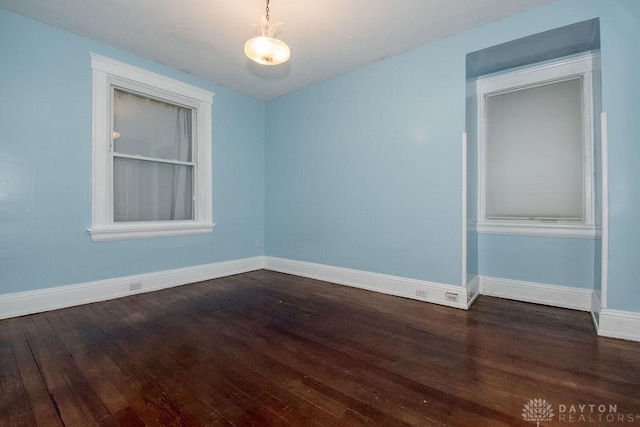 unfurnished room with dark wood-type flooring