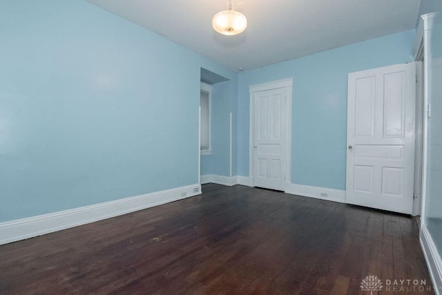 unfurnished room featuring dark wood-type flooring