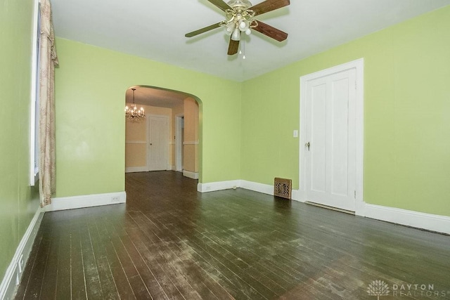 spare room with dark hardwood / wood-style floors and ceiling fan with notable chandelier