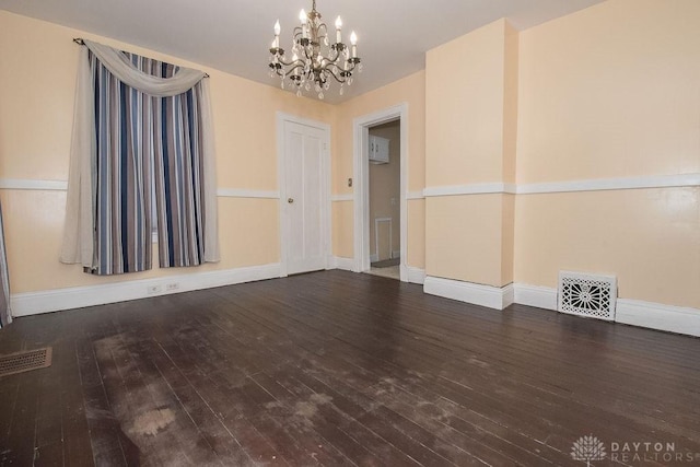 unfurnished room with an inviting chandelier and hardwood / wood-style floors