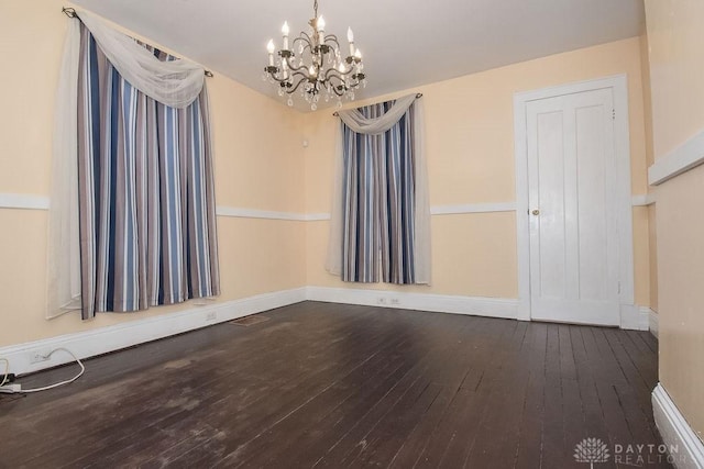 unfurnished room featuring hardwood / wood-style flooring and a chandelier