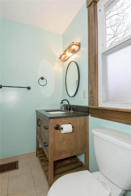 bathroom with tile patterned flooring, vanity, and toilet