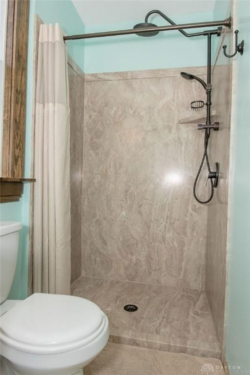 bathroom featuring curtained shower and toilet