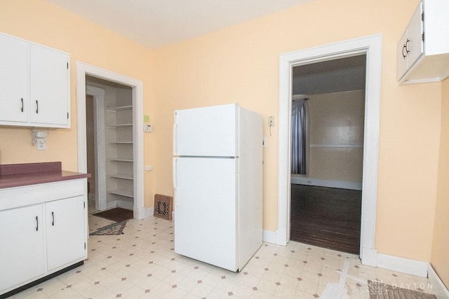 kitchen with white cabinetry and white fridge