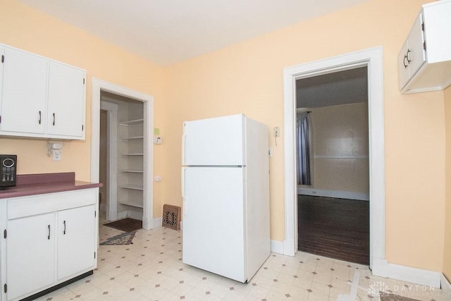 kitchen featuring white fridge and white cabinets