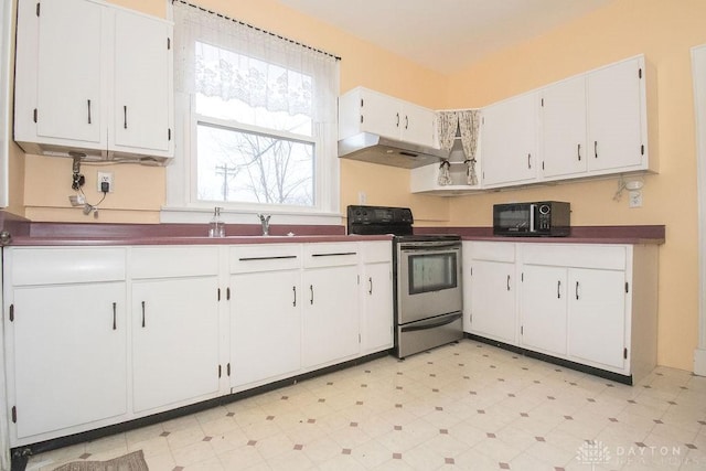 kitchen with stainless steel electric range and white cabinets