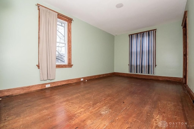 spare room with lofted ceiling and hardwood / wood-style floors