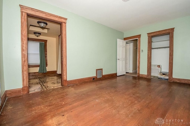 unfurnished bedroom with dark hardwood / wood-style flooring