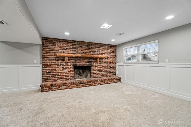 unfurnished living room featuring a brick fireplace and carpet flooring