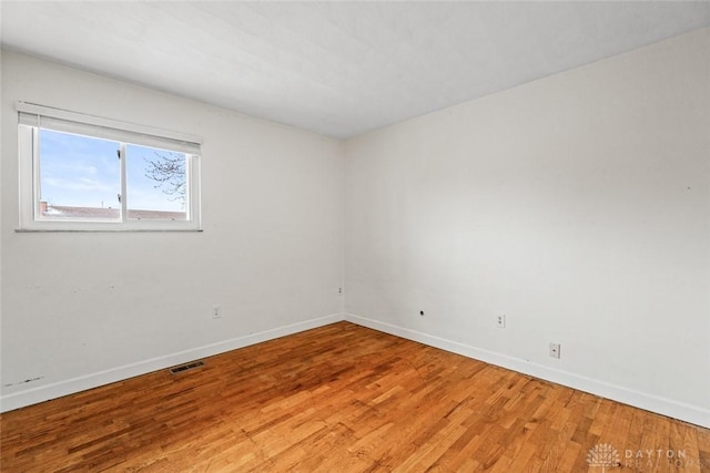 unfurnished room with hardwood / wood-style flooring