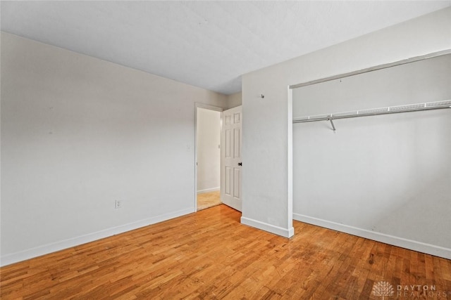 unfurnished bedroom with a closet and light hardwood / wood-style flooring