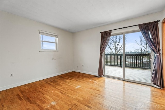 empty room featuring plenty of natural light and light hardwood / wood-style floors