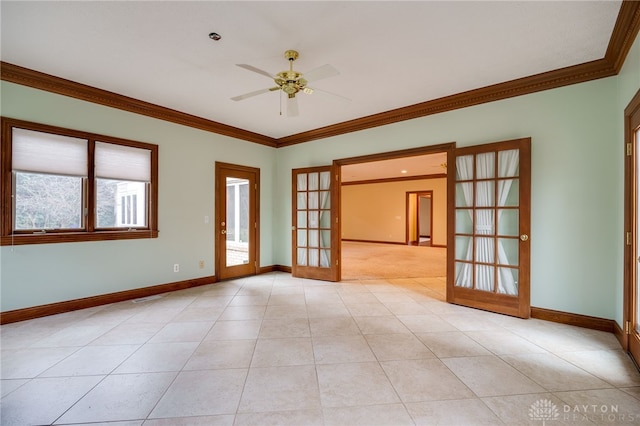 empty room with baseboards, ornamental molding, ceiling fan, and french doors