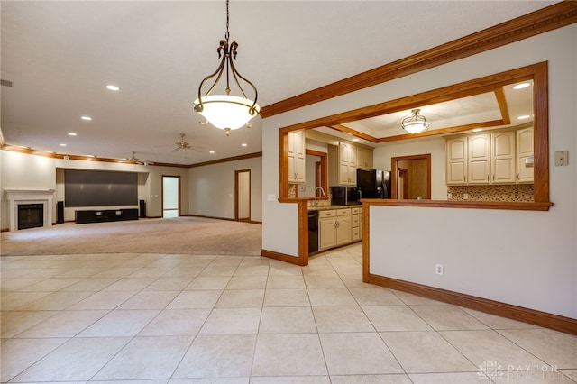 kitchen with a raised ceiling, light tile patterned floors, black appliances, ceiling fan, and ornamental molding
