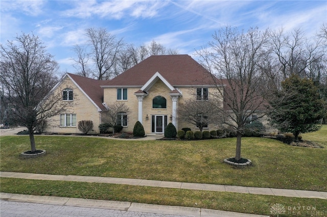 view of front of house with a front lawn and a shingled roof