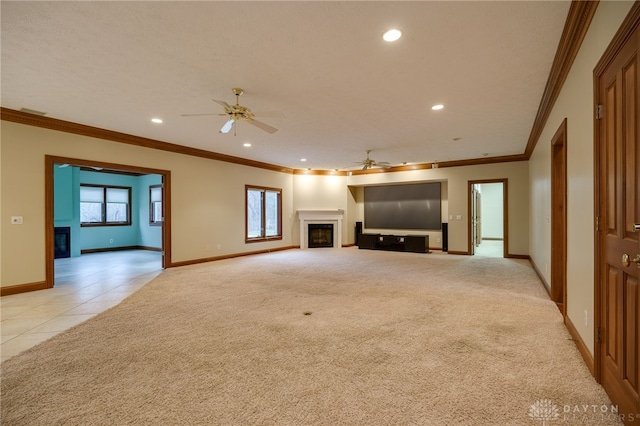 unfurnished living room featuring light colored carpet, a wealth of natural light, a fireplace, and ceiling fan