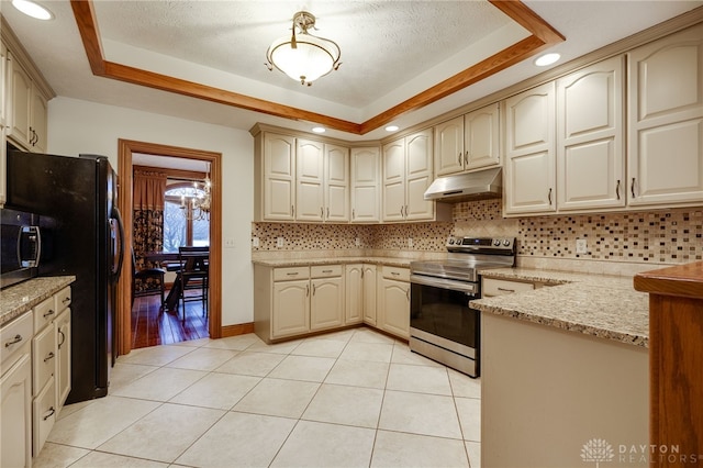 kitchen featuring light tile patterned floors, under cabinet range hood, decorative backsplash, a raised ceiling, and appliances with stainless steel finishes