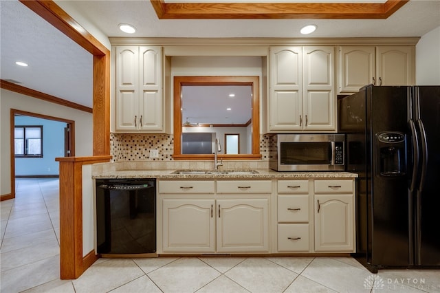 kitchen with a sink, tasteful backsplash, cream cabinets, black appliances, and ornamental molding