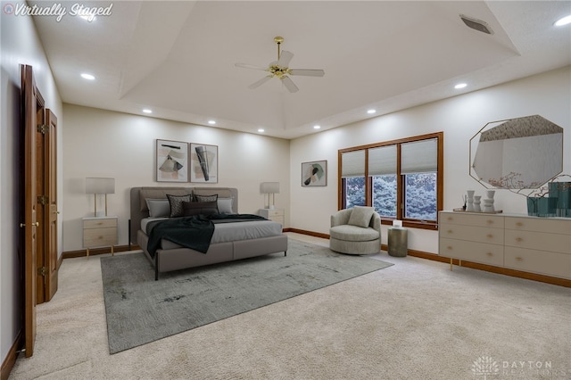 carpeted bedroom featuring baseboards, visible vents, recessed lighting, and a raised ceiling
