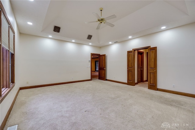 carpeted empty room featuring visible vents, baseboards, recessed lighting, a ceiling fan, and a raised ceiling