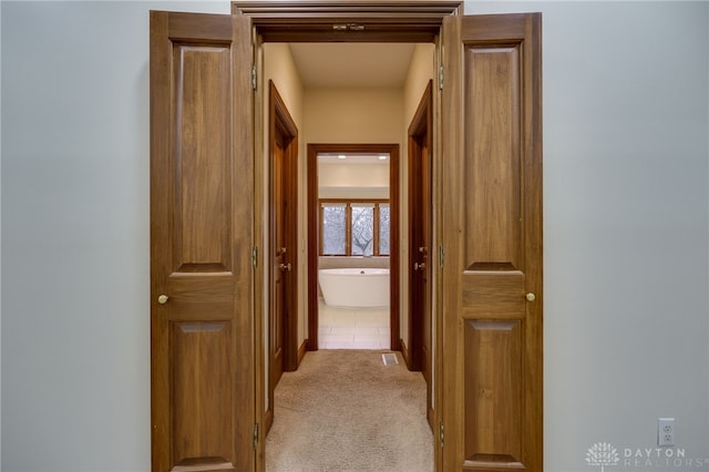 hallway featuring light colored carpet