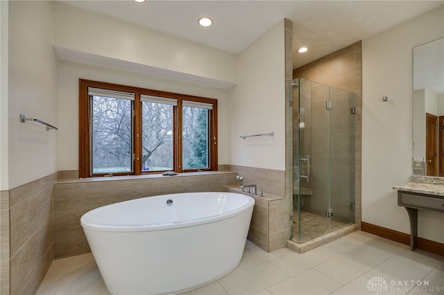 full bathroom with a soaking tub, recessed lighting, tile walls, and a shower stall