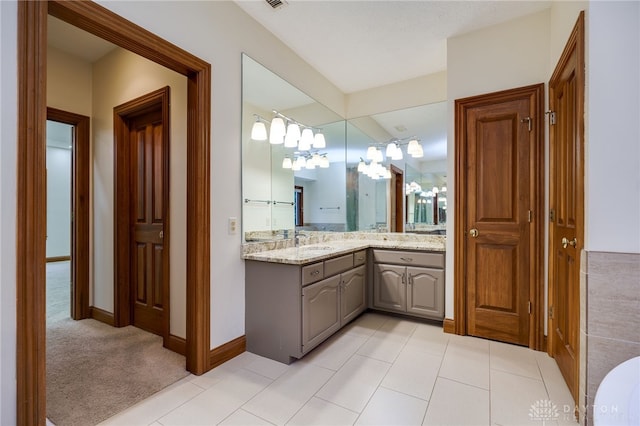 full bath with tile patterned floors, vanity, and baseboards