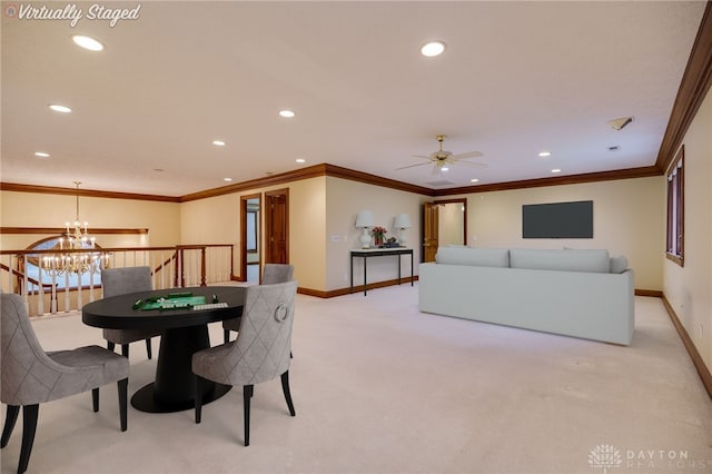 dining space featuring baseboards, crown molding, ceiling fan with notable chandelier, and light carpet
