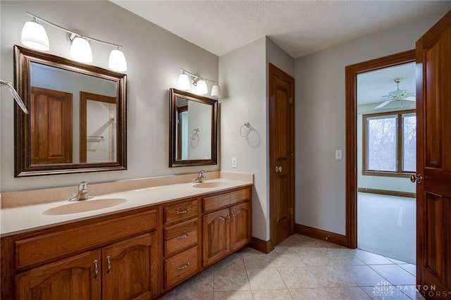 full bathroom with double vanity, a sink, tile patterned floors, and a textured ceiling