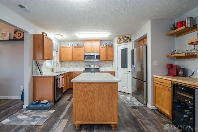 kitchen featuring sink, wine cooler, a center island, stainless steel appliances, and dark wood-type flooring