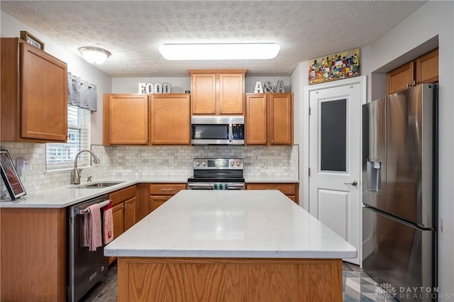 kitchen with sink, stainless steel appliances, a textured ceiling, a kitchen island, and decorative backsplash