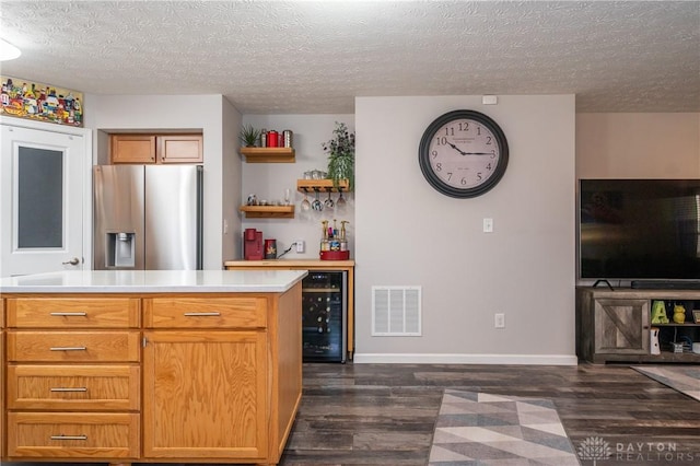 kitchen featuring stainless steel refrigerator with ice dispenser, dark hardwood / wood-style floors, beverage cooler, and a textured ceiling