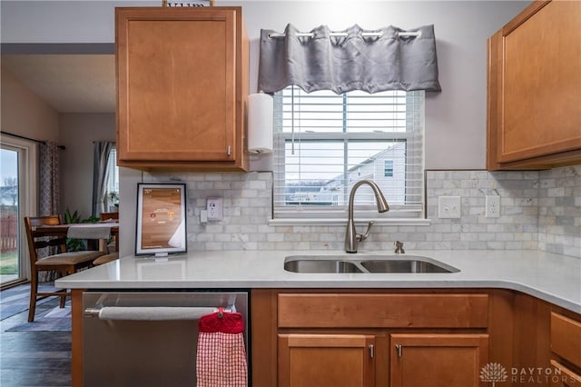 kitchen with dishwasher, sink, dark wood-type flooring, and decorative backsplash